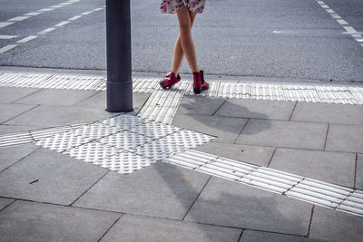 Low section of woman walking on footpath