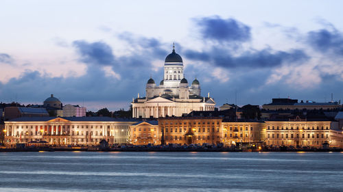 Buildings in city against cloudy sky