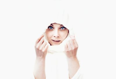 Portrait of young woman wearing scarf over white background