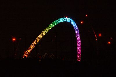 Illuminated ferris wheel in city at night