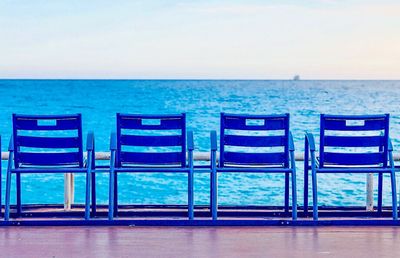 Chairs on beach against sky