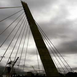 Low angle view of bridge against cloudy sky