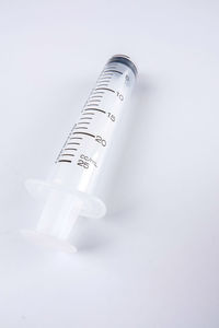 Close-up of syringe over white background