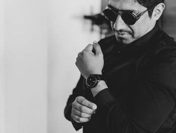 Young man wearing sunglasses while standing indoors