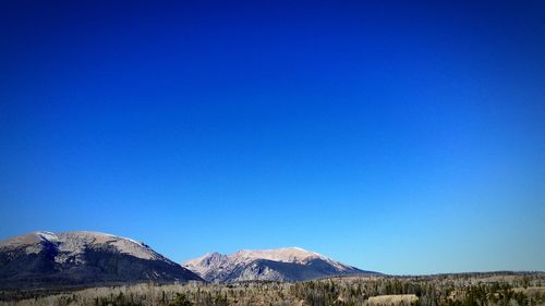 Scenic view of mountains against clear blue sky