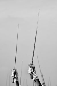 Low angle view of people holding rope against sky