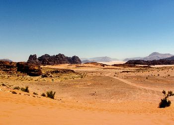 Scenic view of desert against clear blue sky