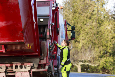 Woman operating garbage truck