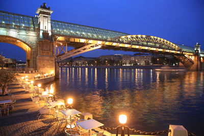 Illuminated bridge over river at night