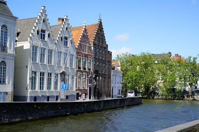 Canal amidst buildings in city against sky