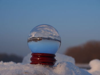 Close-up of ice crystals against sky during winter