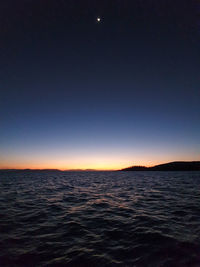 Scenic view of sea against clear sky at night