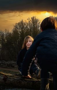 Boys against trees during sunset