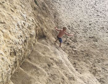 High angle view of boy on steps at beach