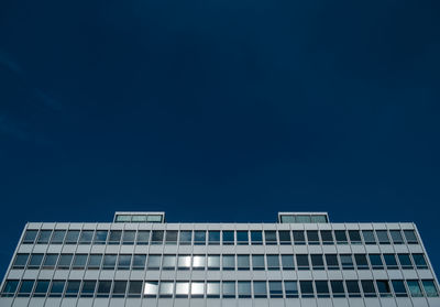 Low angle view of modern office building against clear blue sky