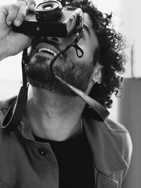 Close-up of bearded man photographing with camera