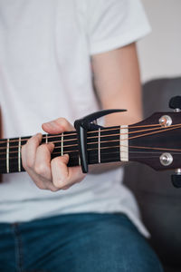 Midsection of man playing guitar