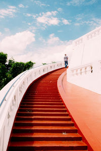 Low angle view of steps on circular staircase against sky