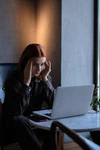 Young woman using laptop at table