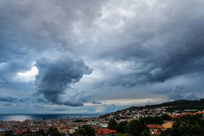 Aerial view of city and buildings against storm clouds