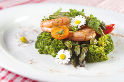 Prawns, asparagus and broccoli with edible daisy flowers.