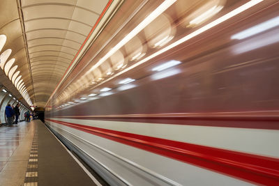 Blur image of train in illuminated railroad station