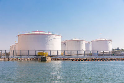 White fuel storage tank in an industrial area near the river