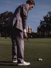 Rear view of man standing on golf course