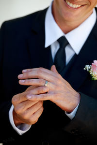 Midsection of bridegroom holding bouquet