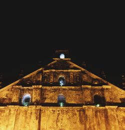 Illuminated building against clear sky at night