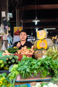 Portrait of smiling woman with vegetables in store