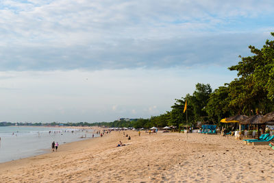 People at beach against sky