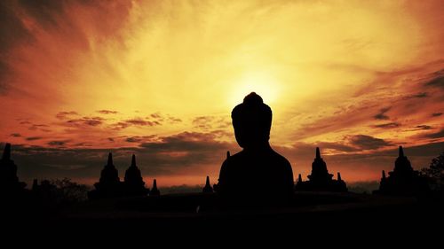 Silhouette statue against sky during sunset