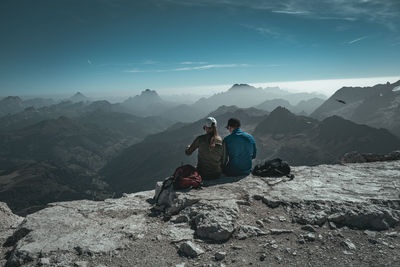 Rear view of man sitting on mountain