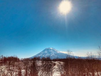 Scenic view of snowcapped mountains against blue sky