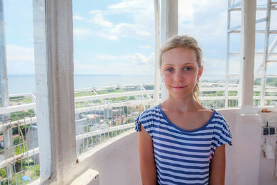 Portrait of girl standing by window