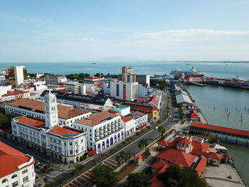 High angle view of buildings by sea against sky