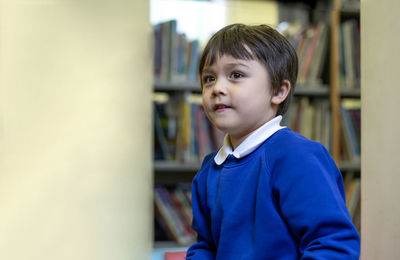 Cute schoolboy looking away in classroom of elementary school