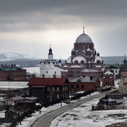 View of religious buildings in city against sky during winter