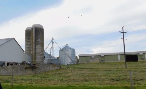 Factory on field against sky