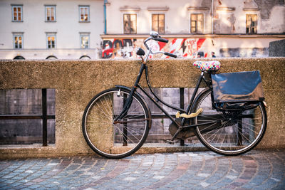 Bicycle parked on street by building