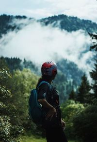 Side view of woman standing while looking at mountain