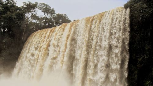 Low angle view of waterfall against sky