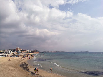 People on beach against sky