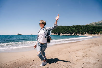 Full length of man standing on beach against sky