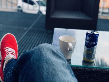 Low section of person with coffee cup on table