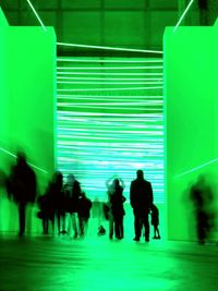 Group of people walking in illuminated modern building