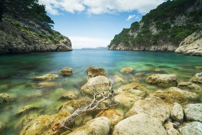 Scenic view of rocks in sea against sky