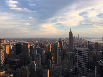 Aerial view of cityscape against cloudy sky