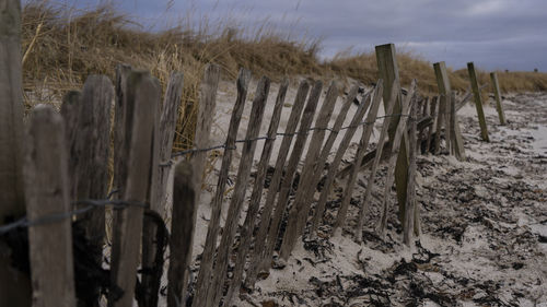 Wooden fence on field against sky